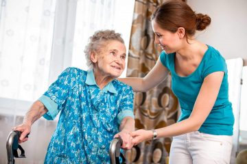 Une femme âgée se faisant aider par une femme plus jeune