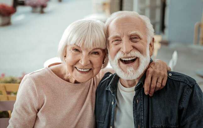 Un couple de personnes âgés complices, heureux et souriants.